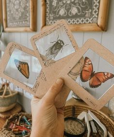 a person holding up some cards with pictures of butterflies on them