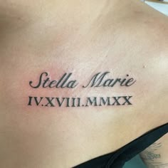 the back of a woman's shoulder with roman numerals tattoo on it