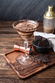 a chocolate martini is served on a wooden tray