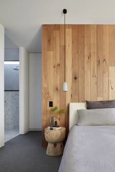 a bedroom with wood paneling and a bed in the corner next to a wall