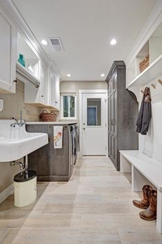 a long narrow kitchen with white cabinets and wood flooring