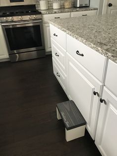 a kitchen with white cabinets and granite counter tops, stainless steel oven and dishwasher