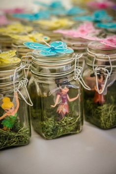 jars filled with tiny fairy figurines sitting on top of a table