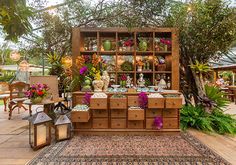 an outdoor area with lots of potted plants and flowers on display in wooden crates