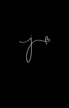 the word j is written in white ink on a black background with a small heart