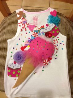 an ice cream cone decorated with pink, purple and green decorations on a white tank top