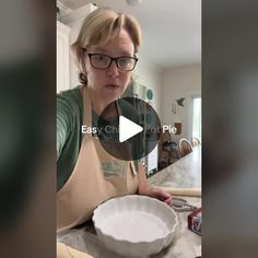 a woman wearing glasses and an apron holding a bowl