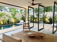 a living room filled with furniture next to a swimming pool