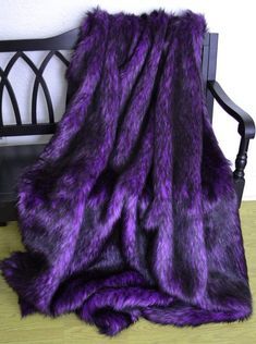 a purple and black blanket sitting on top of a bench