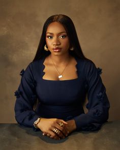 a woman sitting at a table with her arms crossed