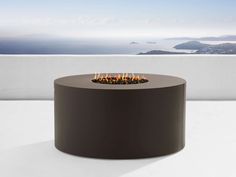 an outdoor fire pit sitting on top of a white table