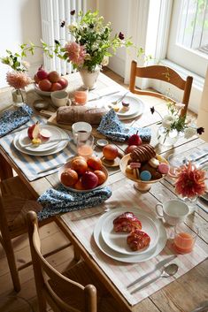 the table is set with plates and bowls of food