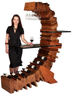 a woman standing in front of a wine rack made out of wooden planks and bottles