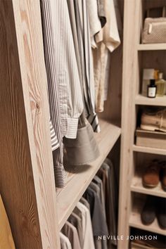 a wooden closet filled with lots of clothes