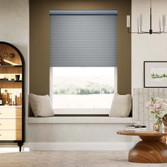 a living room filled with furniture and a window covered in blind shades on the windowsill