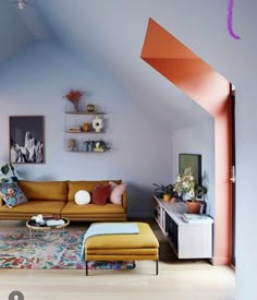 a living room with an orange couch and colorful rug on the floor in front of it