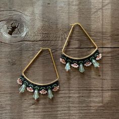 a pair of earrings on top of a wooden table