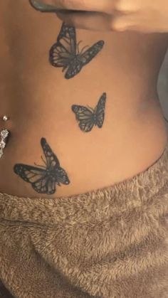 a woman's stomach with butterflies on her side and the bottom part of her belly