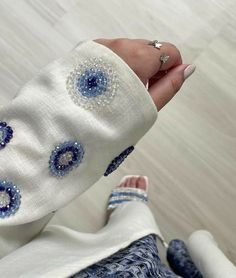 a woman's hand with blue and white designs on it