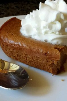 a piece of pie with whipped cream on top and a spoon sitting next to it