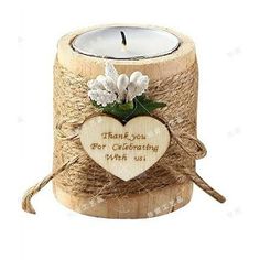 a wooden candle holder with a heart and flowers on the front, tied in twine