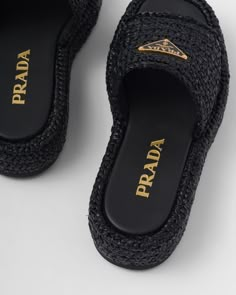 a pair of black slippers with gold lettering on the bottom and an open toe