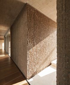 the inside of a building with wooden floors and walls covered in woven fabric, as well as wood flooring