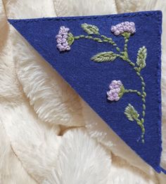 a blue triangle with purple flowers on it sitting on a white furnishing area