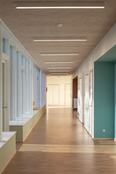 an empty hallway with blue walls and wooden floors