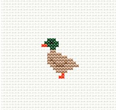 a cross stitch pattern with two green and red birds on it's back side