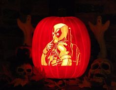 a pumpkin carved to look like the character deadpool is lit up in the dark