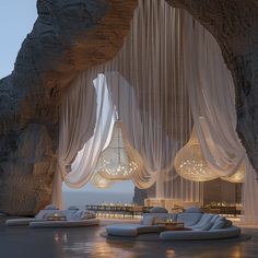 an indoor lounge area with white drapes hanging from the ceiling