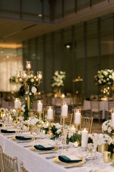 a table set up with candles and flowers for a formal dinner or wedding reception in an elegant setting