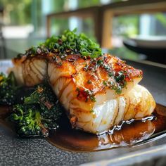 some fish and broccoli on a plate with sauce in the middle for garnish