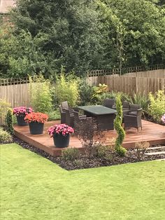 an outdoor deck surrounded by flowers and plants