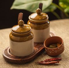 two salt and pepper shakers sitting on top of a table next to a bowl