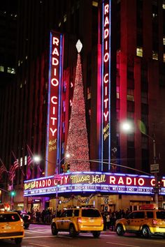 the radio city christmas tree is lit up at night