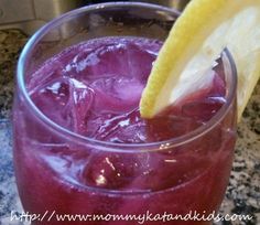 a close up of a drink in a glass with a lemon wedge sticking out of it