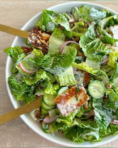 a white bowl filled with salad on top of a table