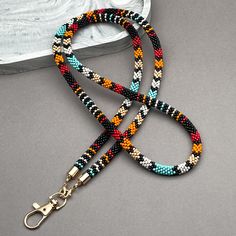 Indulge in the captivating charm of our Native-inspired Beaded Lanyard, a handcrafted accessory that seamlessly blends elegance and functionality. More than just a practical item, it's a thoughtful gift and a stylish statement piece perfect for teachers, office professionals, and anyone who appreciates unique, high-quality accessories. Effortless Elegance and Unwavering Functionality: This lanyard isn't just about aesthetics; it's designed for everyday use. The comfortable 18-inch length allows Seed Bead Lanyard, Teachers Office, Beaded Lanyard, Beaded Lanyards, Handcrafted Accessories, Ethnic Patterns, Effortless Elegance, Badge Holder, Badge Holders Lanyard