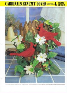 a red bird sitting on top of a basket filled with flowers