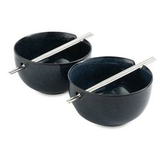 two black bowls with spoons in them