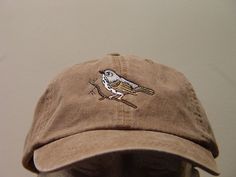 a brown hat with a bird embroidered on it