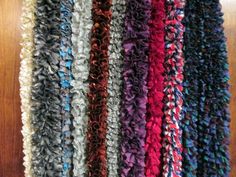 several different colored pieces of fabric on a wooden surface, all lined up in rows