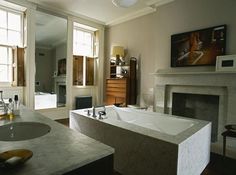 a bathroom with a fireplace, sink and bathtub in it's center area