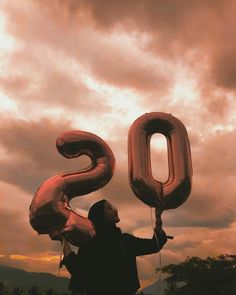 a man holding up the number 50 balloon