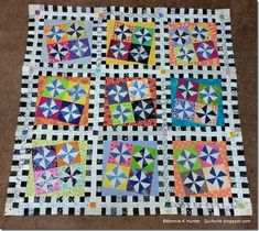 a quilted table topper with many different colored squares on it and black and white checkerboard