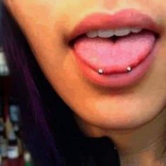 a woman with purple hair and piercing on her tongue