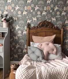 a bedroom with a bed, dresser and wallpaper