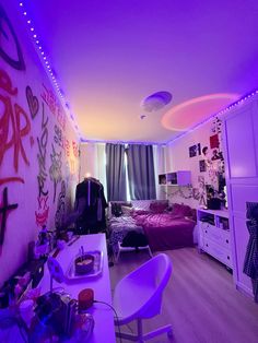 a bedroom with purple lights and graffiti on the walls